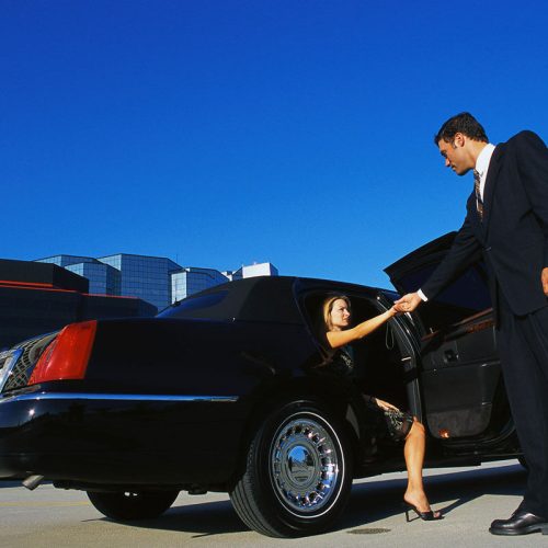 man holding women hand who is sitting in car